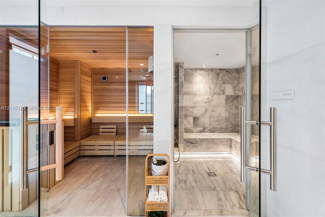 Expansive interior space featuring floor-to-ceiling windows, large-format tile flooring, recessed lighting, and a neutral color palette
