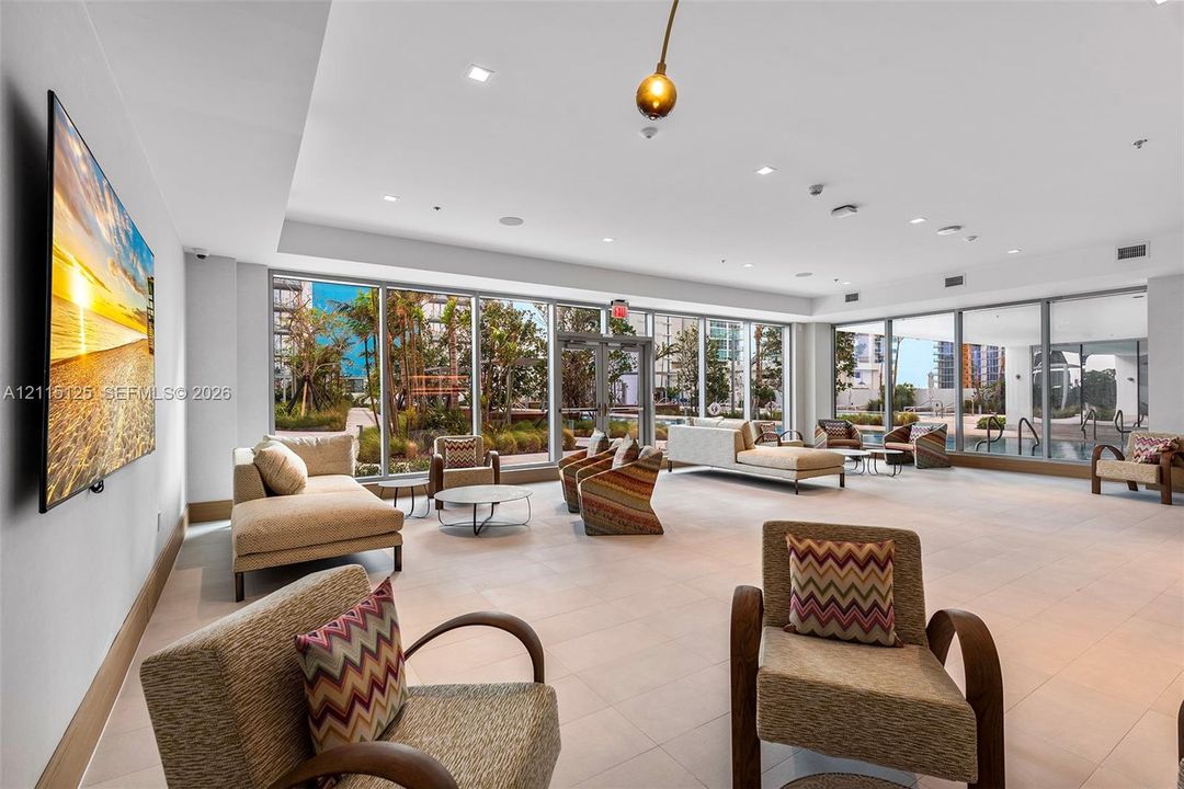 Fitness space featuring floor-to-ceiling glass walls, wood-finish flooring, recessed lighting, and expansive water exposure