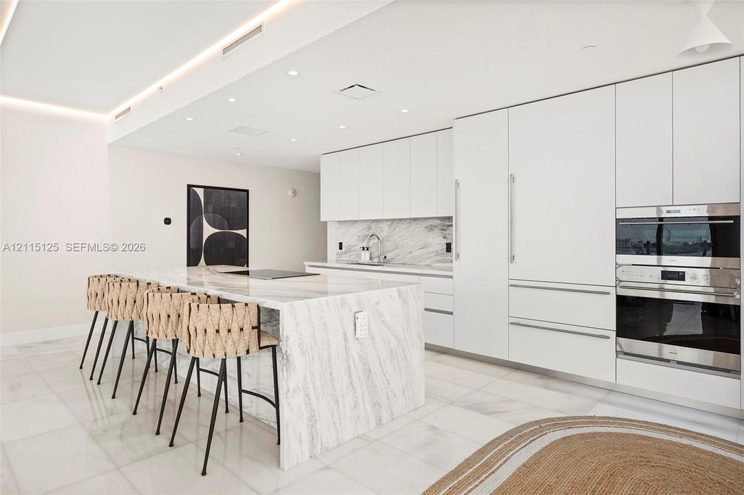 Floor-to-ceiling windows, glass-panel balcony, accent wall, and neutral tile flooring