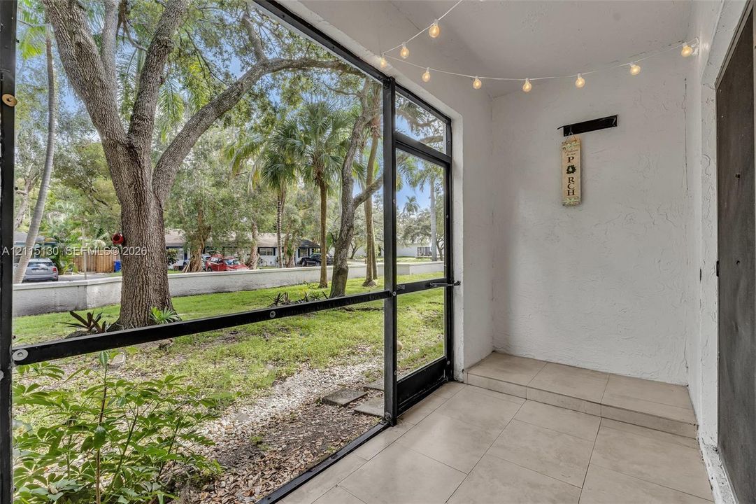 Screened patio featuring ceramic tile flooring, textured wall finishes, and black aluminum framing