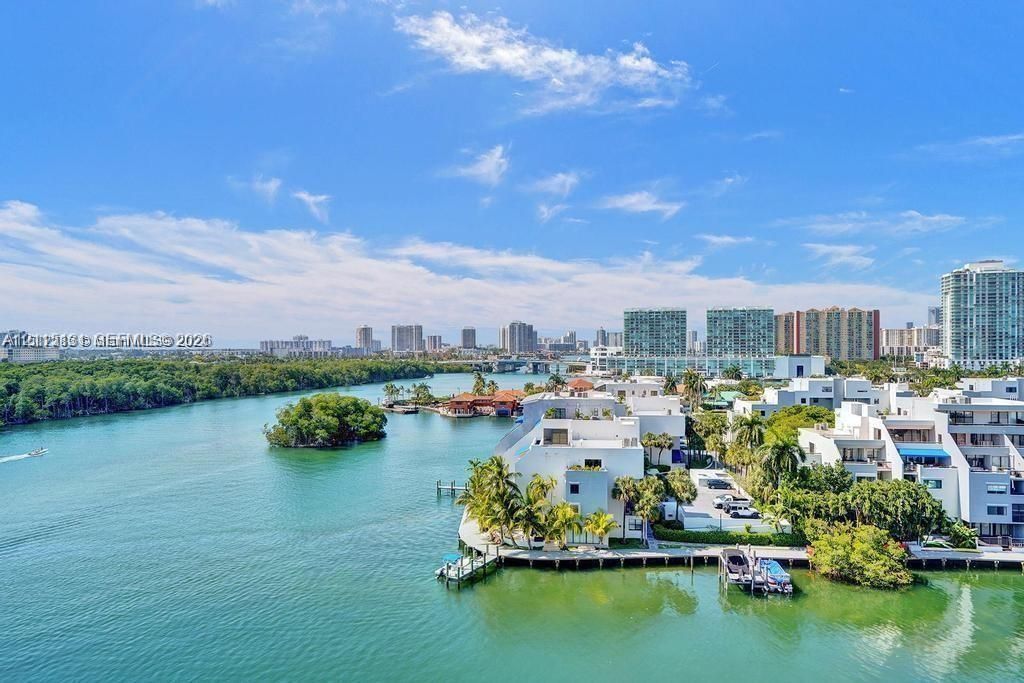 Waterfront property featuring a private boat dock, concrete seawall, and extensive exterior balconies