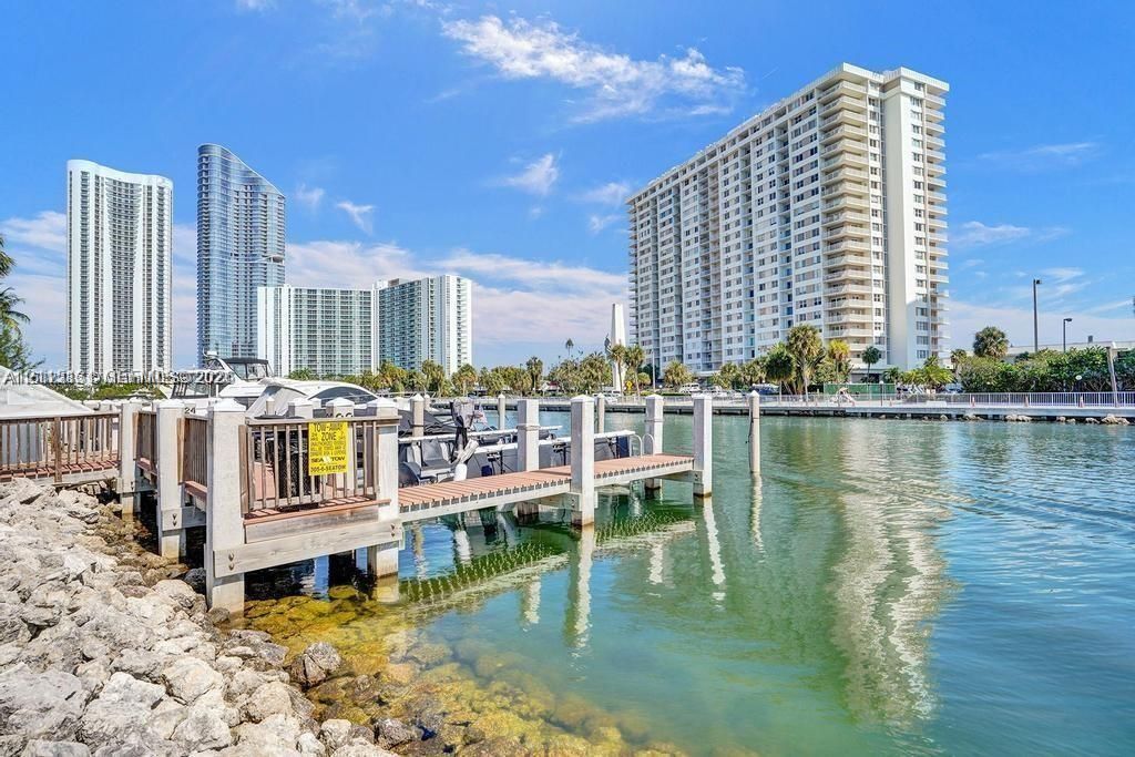 Waterfront deep-water boat slip featuring composite decking, vertical pilings, and a concrete-reinforced shoreline