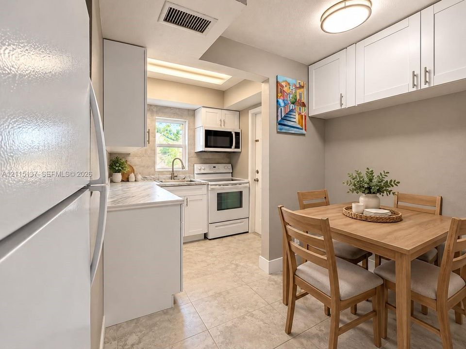Kitchen featuring white shaker-style cabinetry, stone-patterned countertops, a stainless steel sink with a gooseneck faucet, an integrated over-the-range microwave, and light-toned ceramic tile flooring