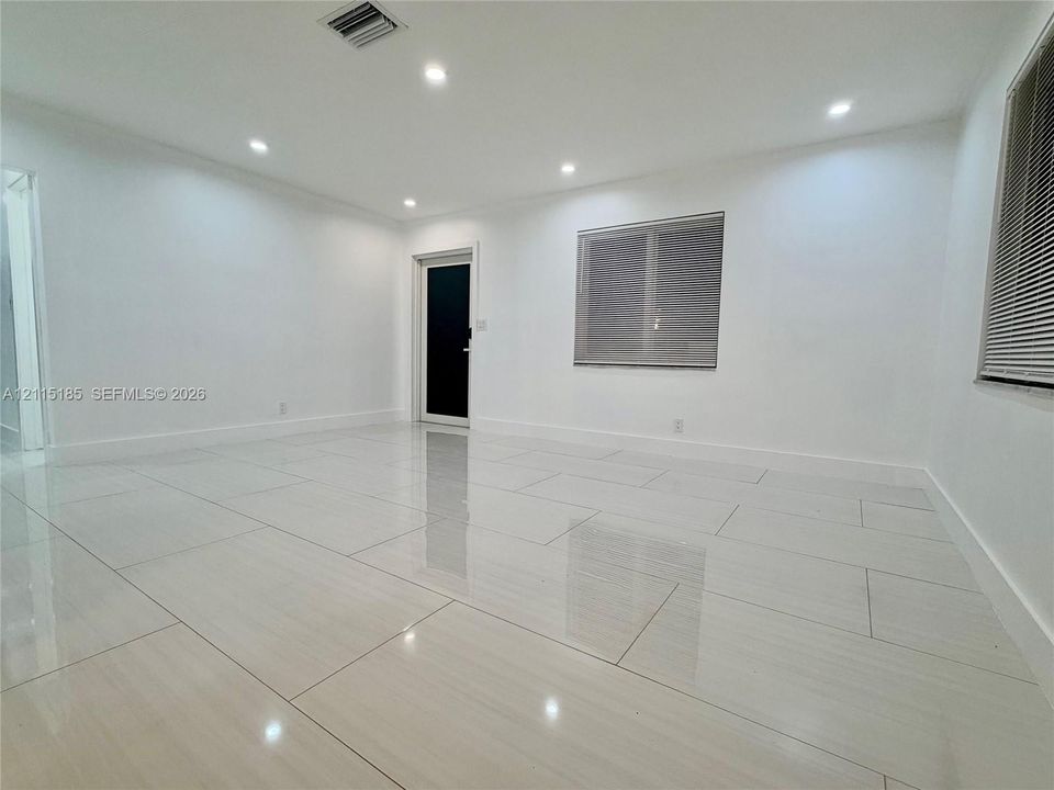 Interior space featuring large-format polished tile flooring, recessed LED ceiling lighting, and a neutral color palette
