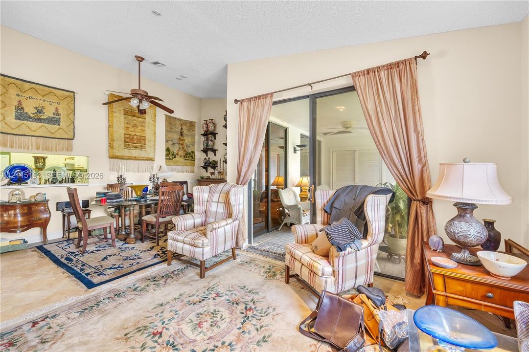 Vaulted ceiling with a central paddle fan, built-in recessed niche shelving, and large sliding glass doors