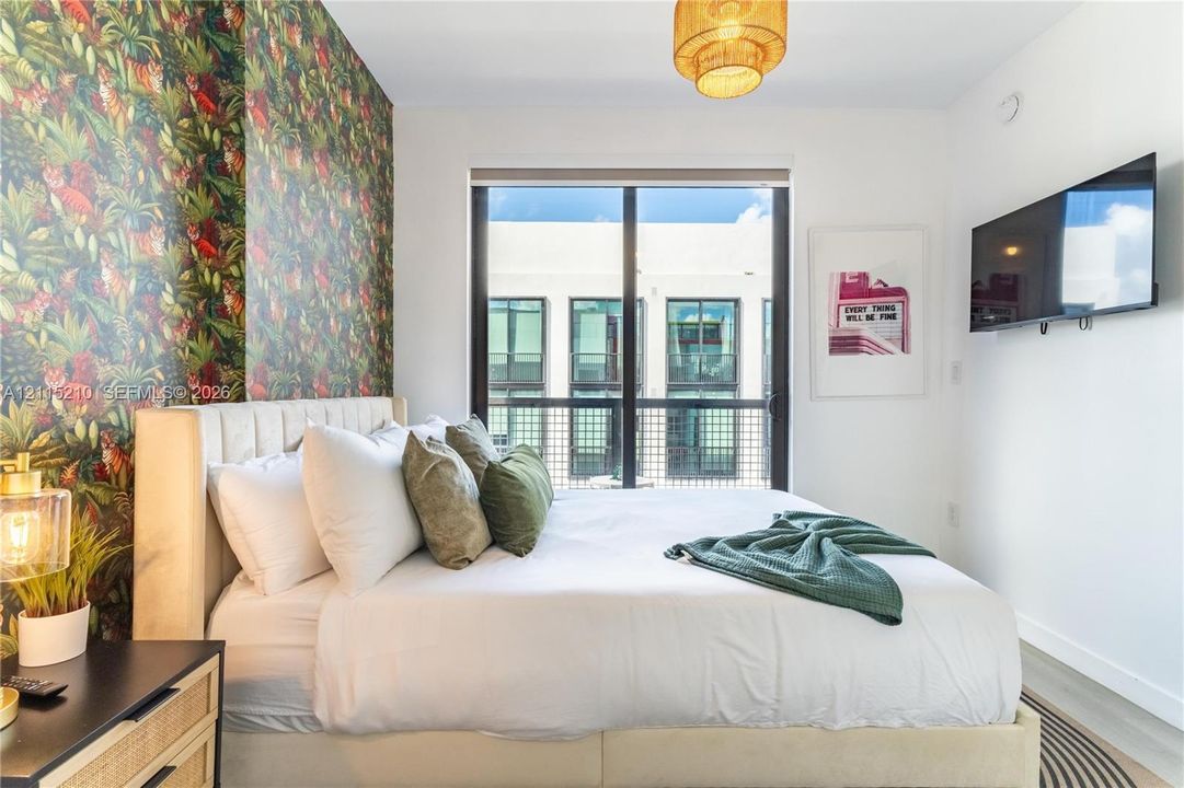 Floor-to-ceiling window with metal frame, patterned accent wall, and pendant lighting fixture