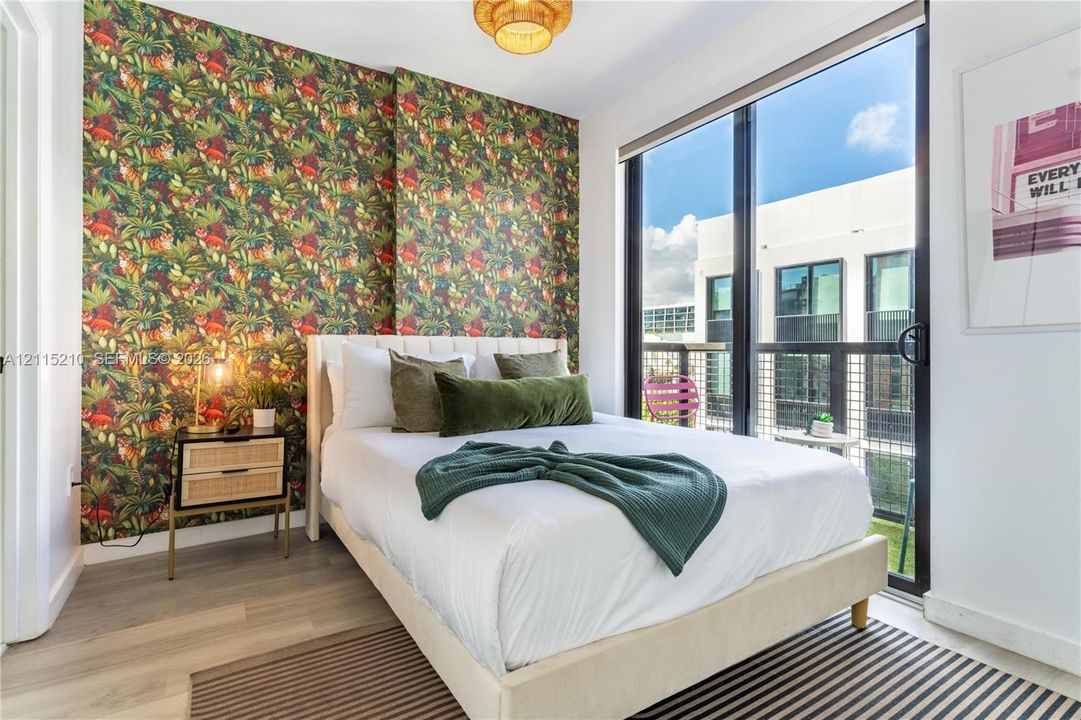 Floor-to-ceiling sliding glass doors, private balcony, wood-finish flooring, and statement patterned wallpaper
