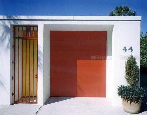 Exterior Front - Front of Cooney House, a Sarasota School of Architecture gem, for rent on an annual basis. The red door is a one-car garage with lots of storage. There is parking for 3 more cars on this property.