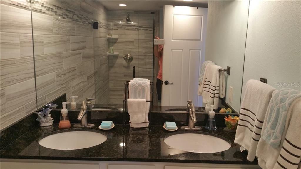 Updated bath offers double sinks and walk-in shower.