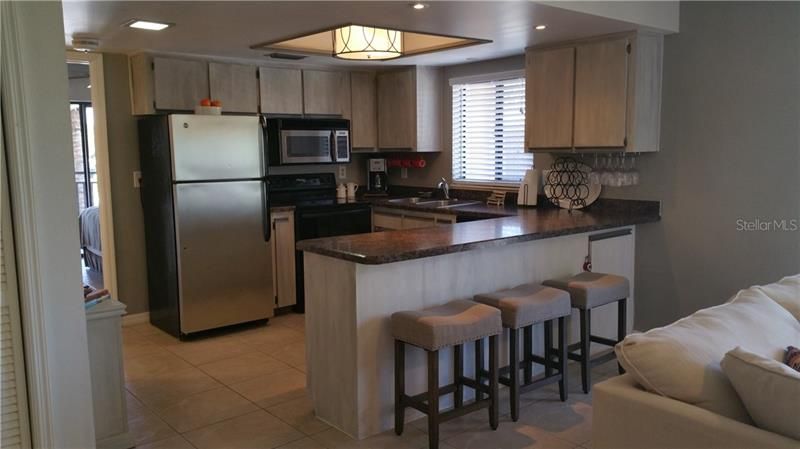 Well lit, fully furnished kitchen offers views of Gulf, breakfast bar and is open to living and dining rooms.