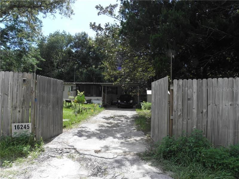 Double gate with lock leading into the 0.34 acre property.