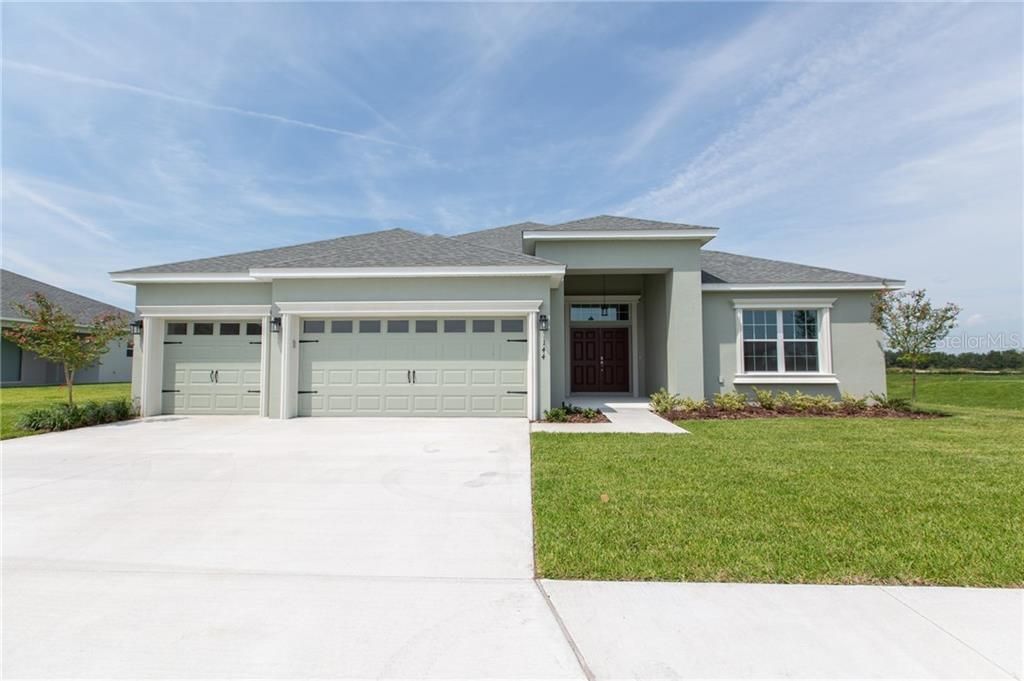 Beautiful! Note the double door entry with transom overhead and the garage doors with carriage straps and windows.