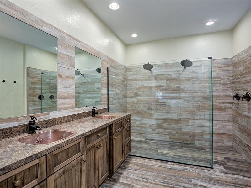 Incredible Custom Master Bath!   Dual Rain Head Shower, Ceramic Wood-look tile, Frameless Glass enclosure, Dual Copper Sinks and plenty of counter space awaits you!