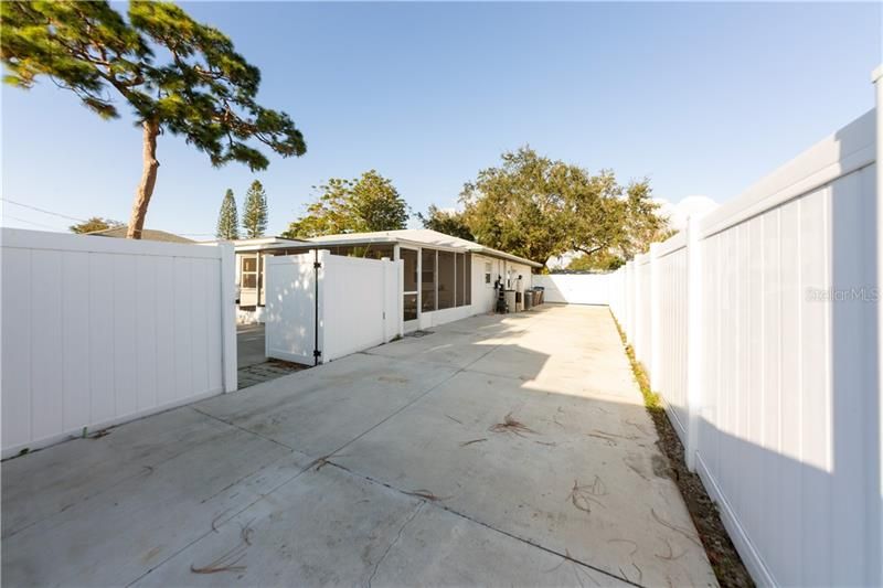 Large, fully fenced parking pad at the side of the home offers secure parking for your boat, RV, or trailer!