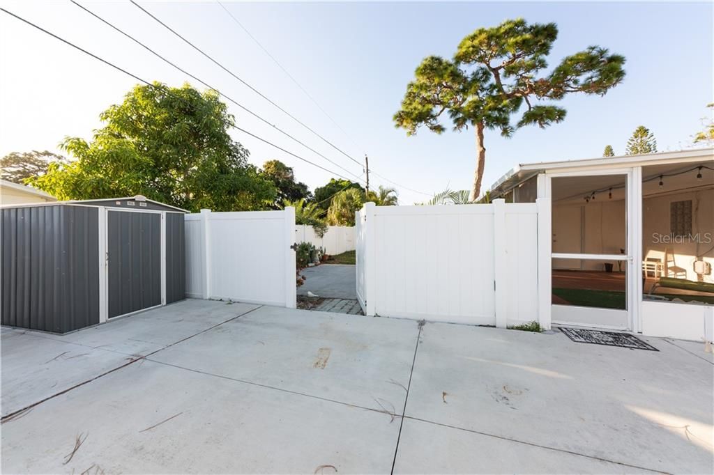 Gate from parking pad, leading into another fenced patio area