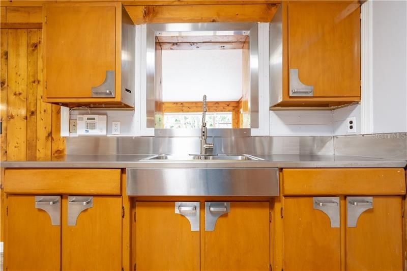 Stainless steel sink in centered in the kitchen overlooking the Florida room
