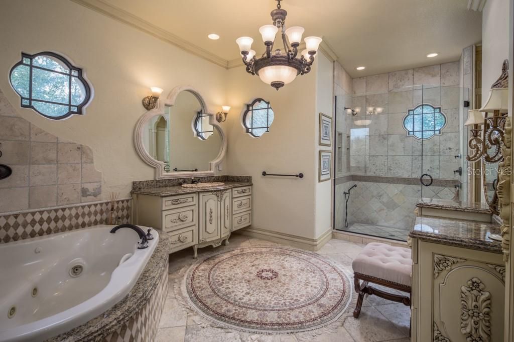 Featuring both his and her bathrooms, hers offers a spa tub, walk-in shower with multiple shower heads and a custom vanity.