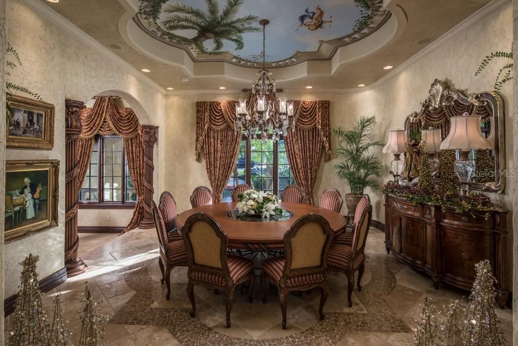 Formal entertaining is offered in the main dining room which features a hand-painted, custom tray ceiling with matching quatrefoil design of stone inlays within the Travertine floor.