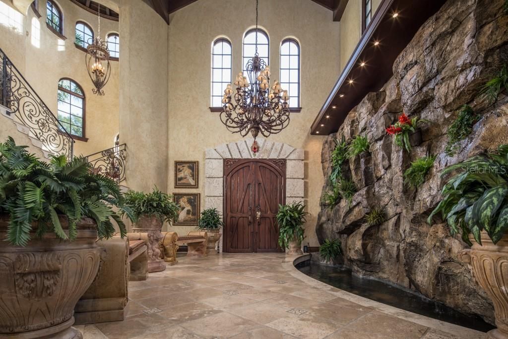 From the lavish entry featuring a custom rock waterfall, grand staircase and two-story vaulted ceiling, the main home spans across two levels.