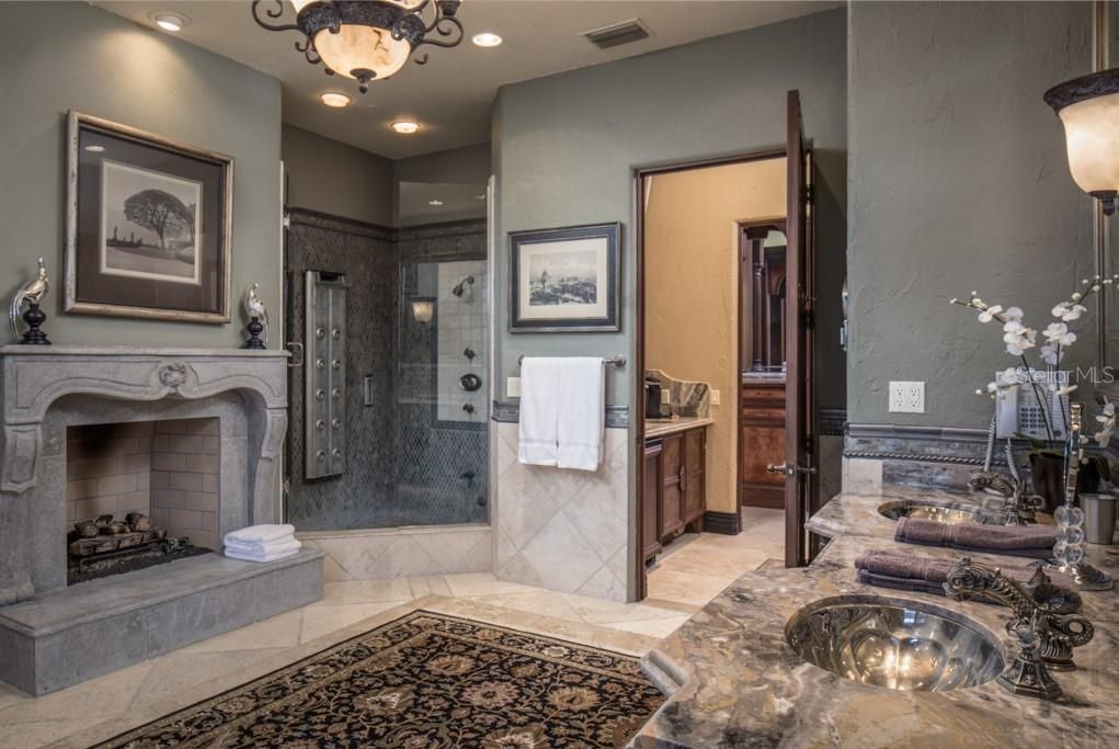 The master bath features a gas fireplace and walk-in shower with multiple shower heads.