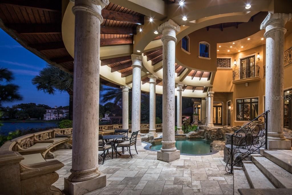 The covered lanai is bordered by a half-moon row of cushioned stone benches for casual lounging and entertaining day or night.