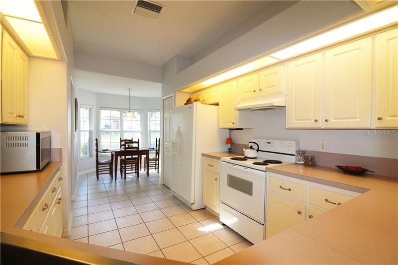 SPACIOUS KITCHEN WITH CLOSET PANTRY AND BREAKFAST BAR OVERLOOKING GREAT ROOM
