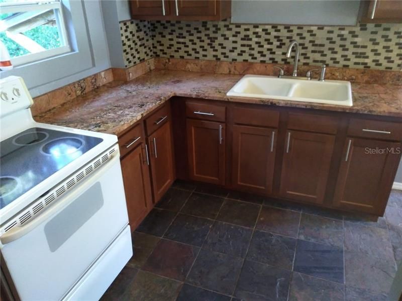 gourmet kitchen wood cabinets -stone floors -granite countertops
