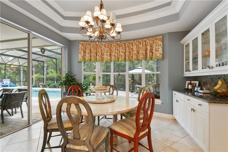 Tray Ceilings in eat in kitchen with pool side view and custom buffet station