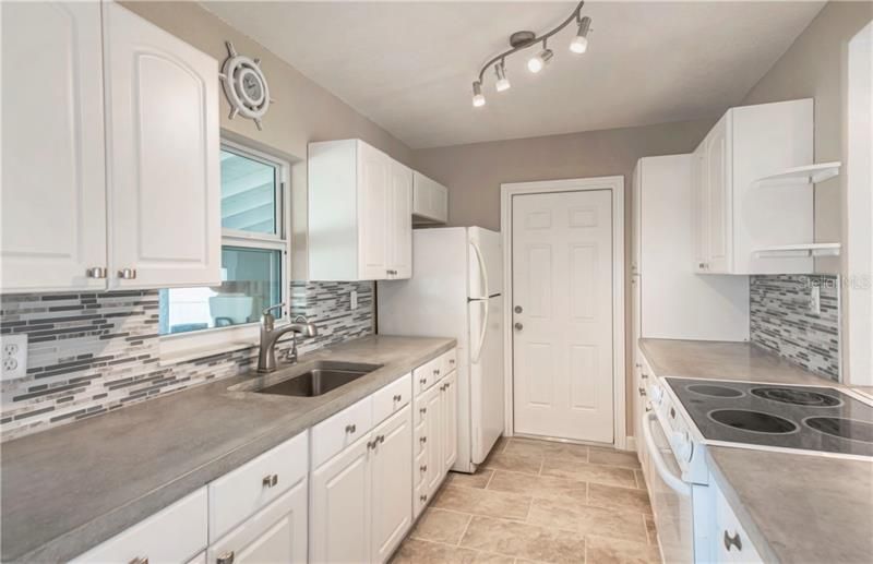 Glass tiled backsplash and unique poured concrete counters!