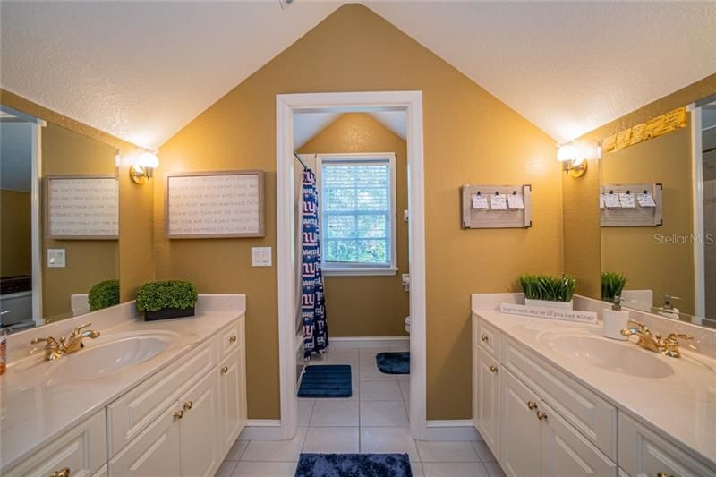 Jack and Jill bathroom with tub/shower, dual vanities.