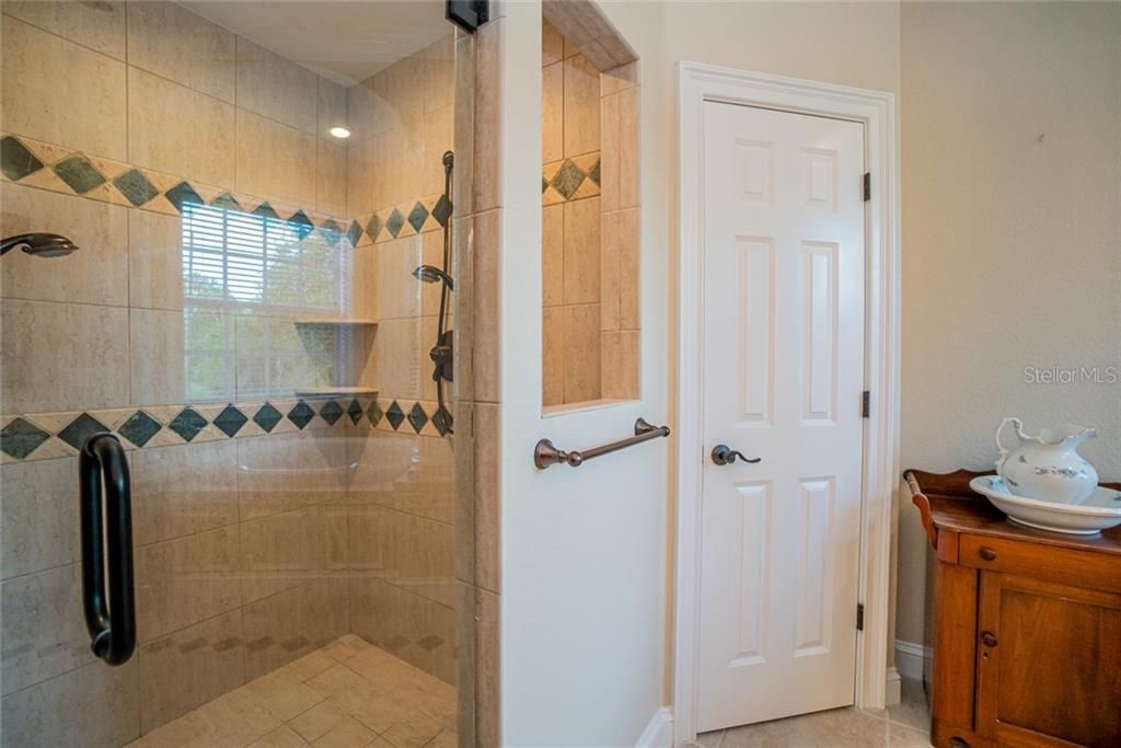 Walk in Shower with dual shower heads and private toilet room.