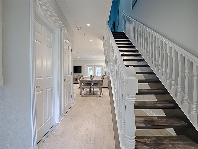 Designer staircase captures your attention! Inviting hallway to dining area on the left.