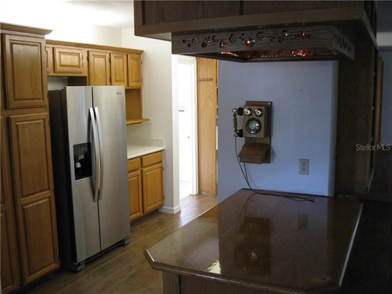 Kitchen showing pantry on left, double door refrigerator, and Breakfast Bar to Living Room.