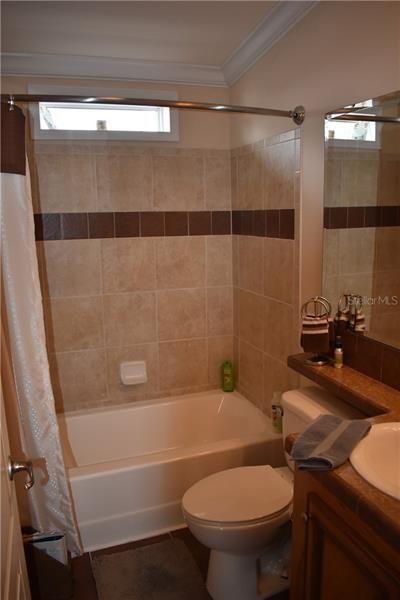 Main bathroom with tub, ceramic tile shower & floor and transom window.