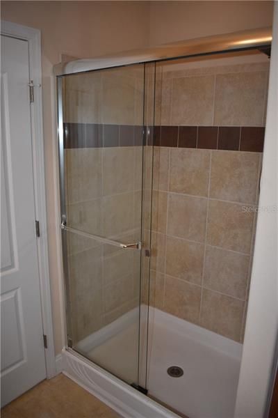 Master bathroom tiled shower w/glass doors.