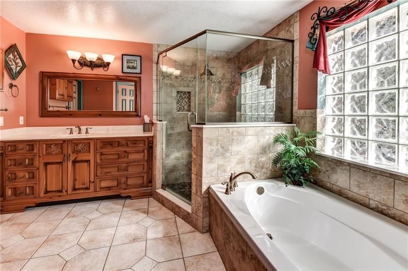Roman tub with large custom shower and carved vanity