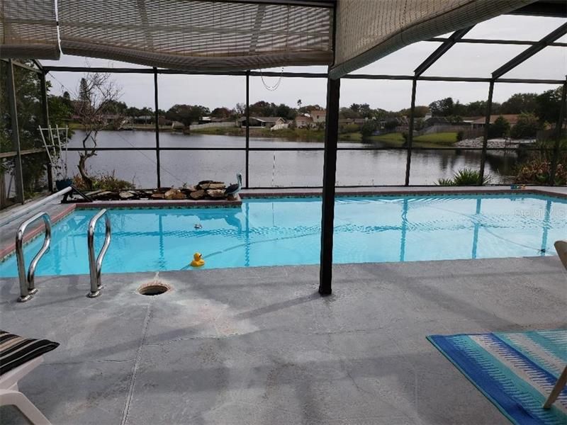 Walking out the sldiing glass doors fromt he master bedroom to the pool overlooking the lake