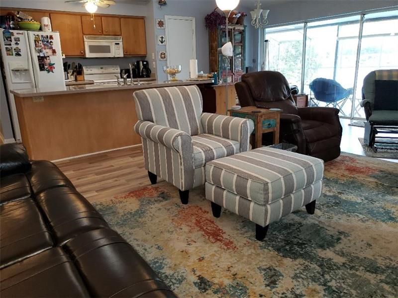 Living room space looking into kitchen and out to pool which overlooks the lake