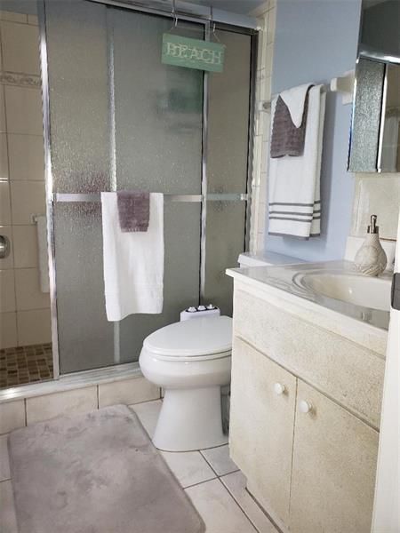 Master bath with beautifully refinshed vanity and newer tile in the shower