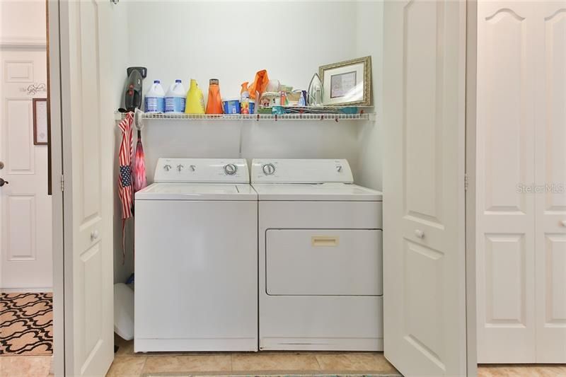 Washer and dryer tucked away in hallway.