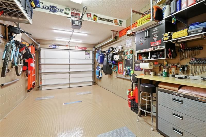 Finished garage with vinyl flooring and built-in storage and workbench