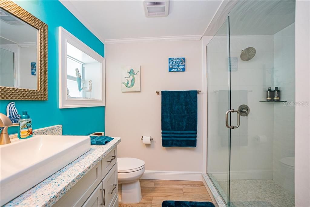 Custom designed 3rd bathroom with recycled glass countertops and stand up shower. Located right inside for easy access from the pool.