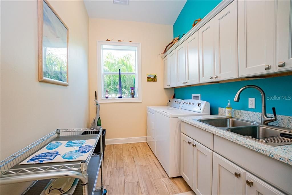 Huge interior laundry room on the 2nd floor with recycled glass counter tops.