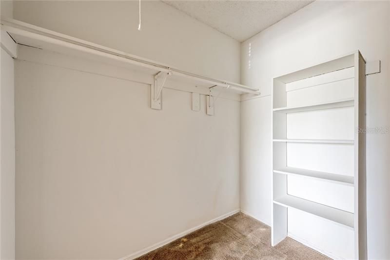 WALK IN CLOSET WITH BUILT IN SHELVING.