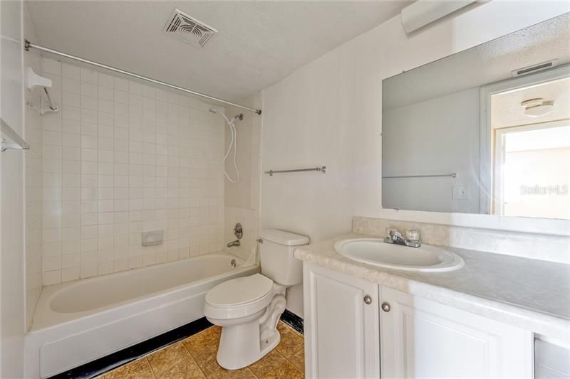 FULL BATHROOM WITH TILED SHOWER.