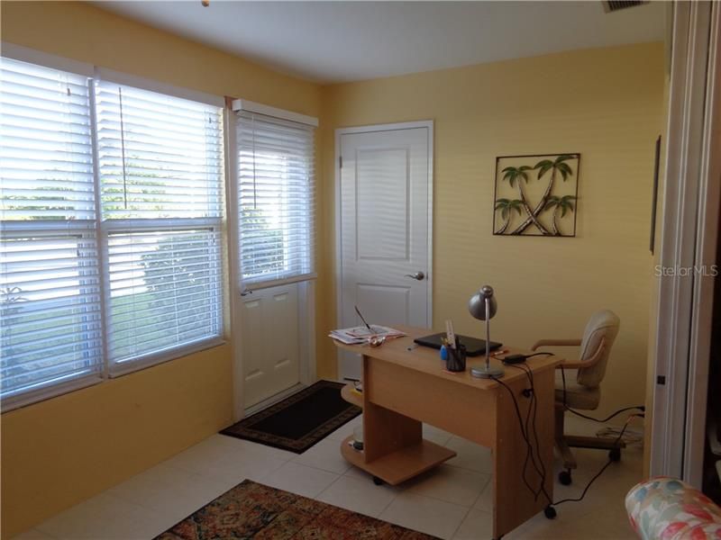 Light and bright Florida room with back door and storage closet.