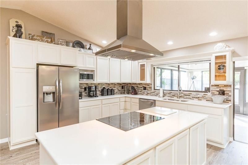 Kitchen featuring White wood cabinetry, stainless steel appliances, and quartz counters.
