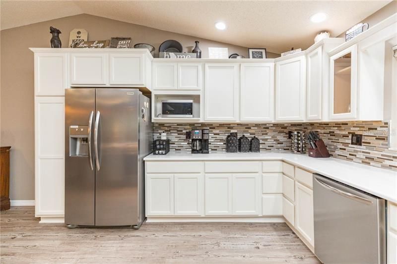 Kitchen featuring White wood cabinetry, stainless steel appliances, and quartz counters.