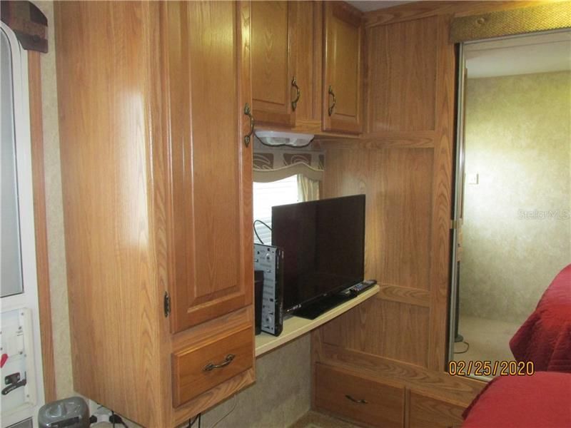 Wood cabinetry extends into the master bedroom.