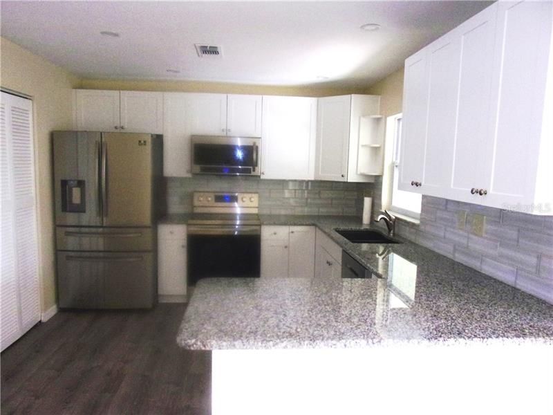 KITCHEN WITH GRANITE COUNTER TOPS AND NEW APPLIANCES